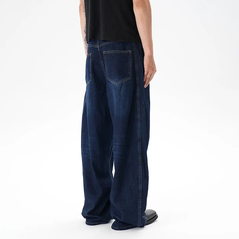 Dark blue washed distressed wide leg machete jeans showing fading and whiskering details