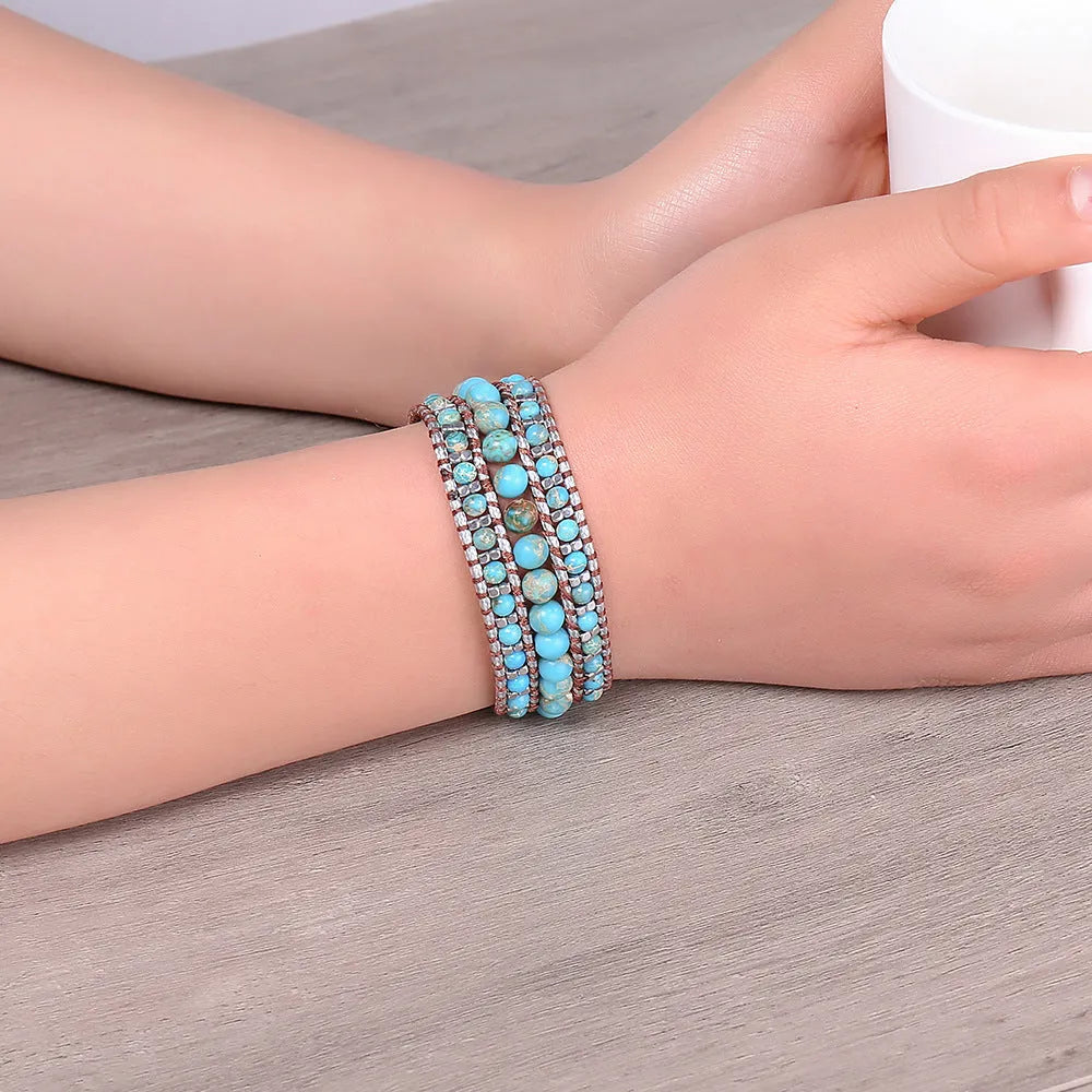 Handmade turquoise geometric inlaid gem bracelet in green with starry sky meteor shower pattern on a white background.