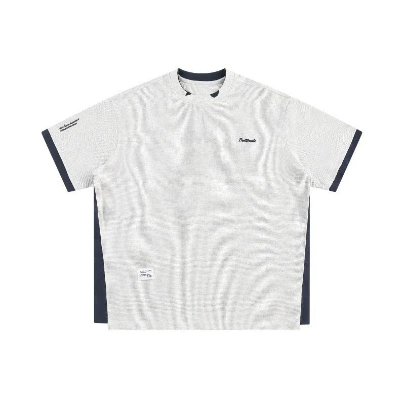 Loose waffle-knit short-sleeved t-shirt with retro alphabet embroidery on the front, shown in navy blue.