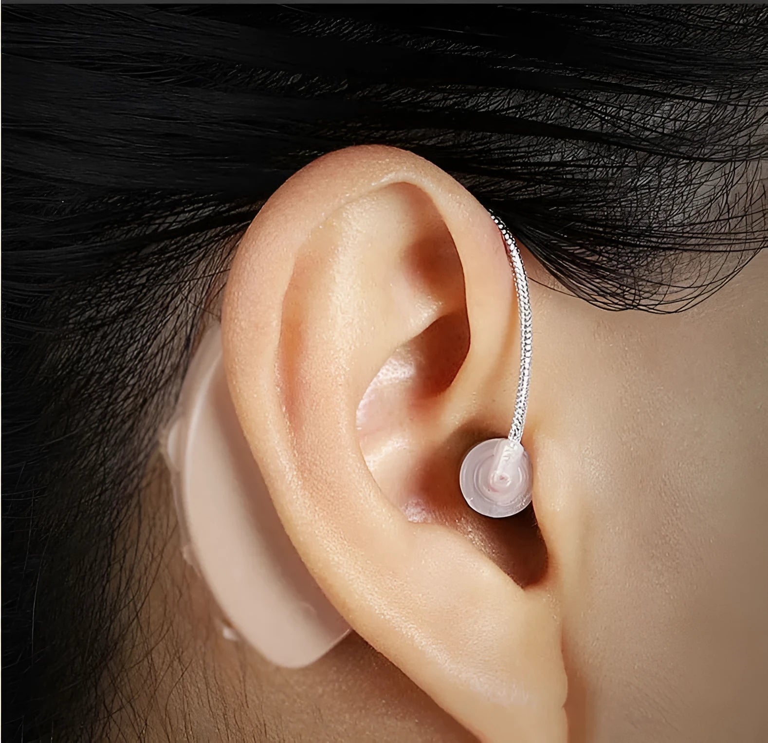 Black rechargeable hearing aid amplifier with silicone housing and charging cable