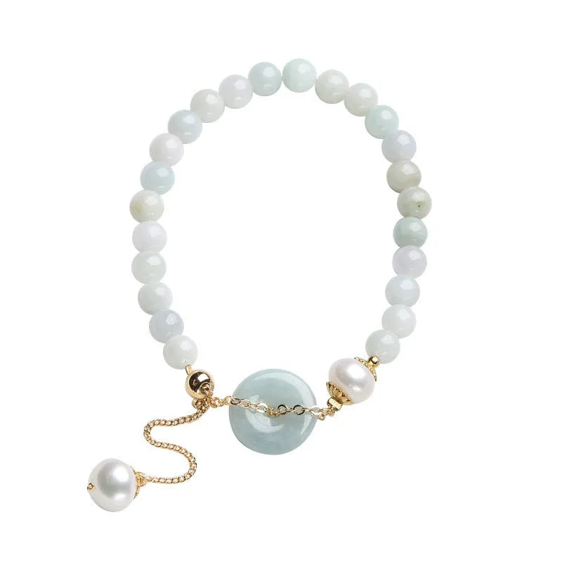 Jade and pearl bracelet with geometric pendant and peace buckle charm on wrist