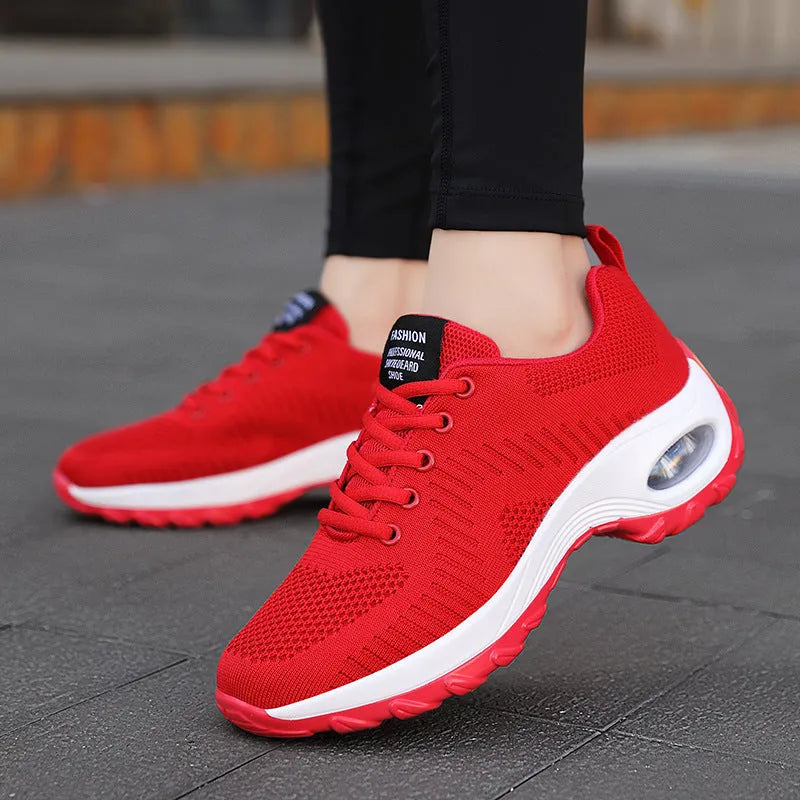 Red and black women's low top lace-up mesh sneakers with a round toe and mid heel.
