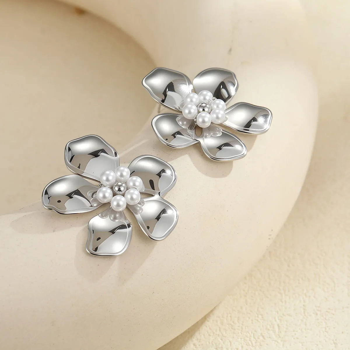 Flower stringed pearls stud earrings in gold and steel colour on white background