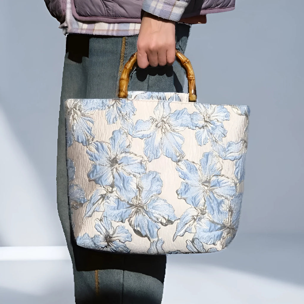 Light blue canvas bag with gold floral pattern showing double shoulder straps and square 30cm shape