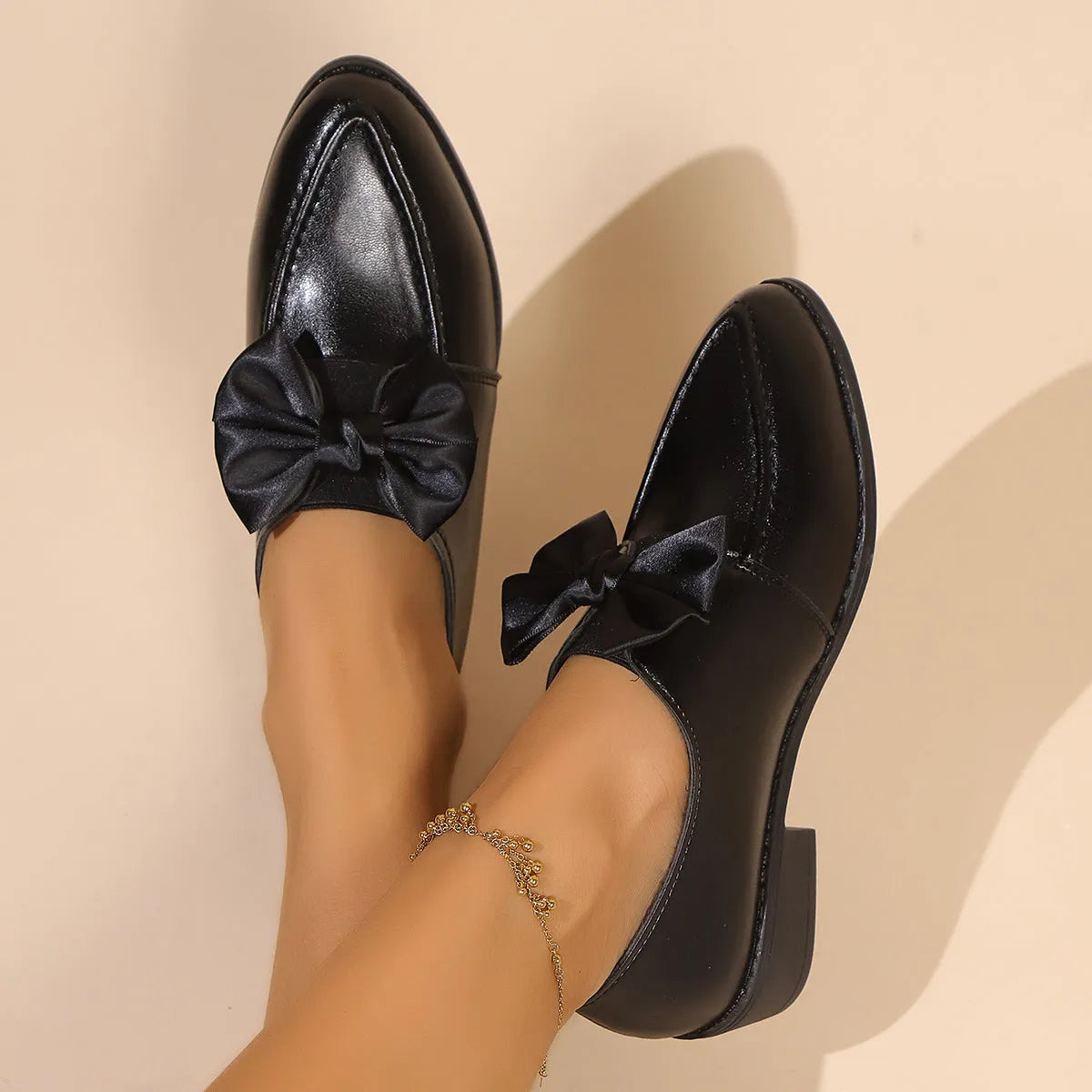 Women's pointed toe PU leather shoes with a bow detail on the upper.