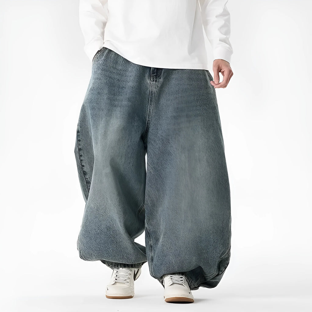 Men's plus-size light blue wide-leg denim jeans with a loose, baggy fit and straight legs on a hanger.