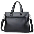Men's black PU leather shoulder messenger bag with splicing detail on a table