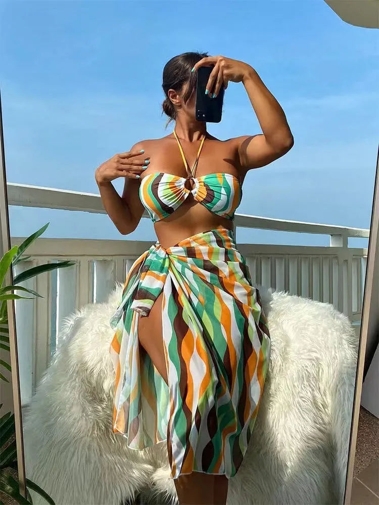 Yellow green women's three-piece bikini set with printed skirt on a hanger.
