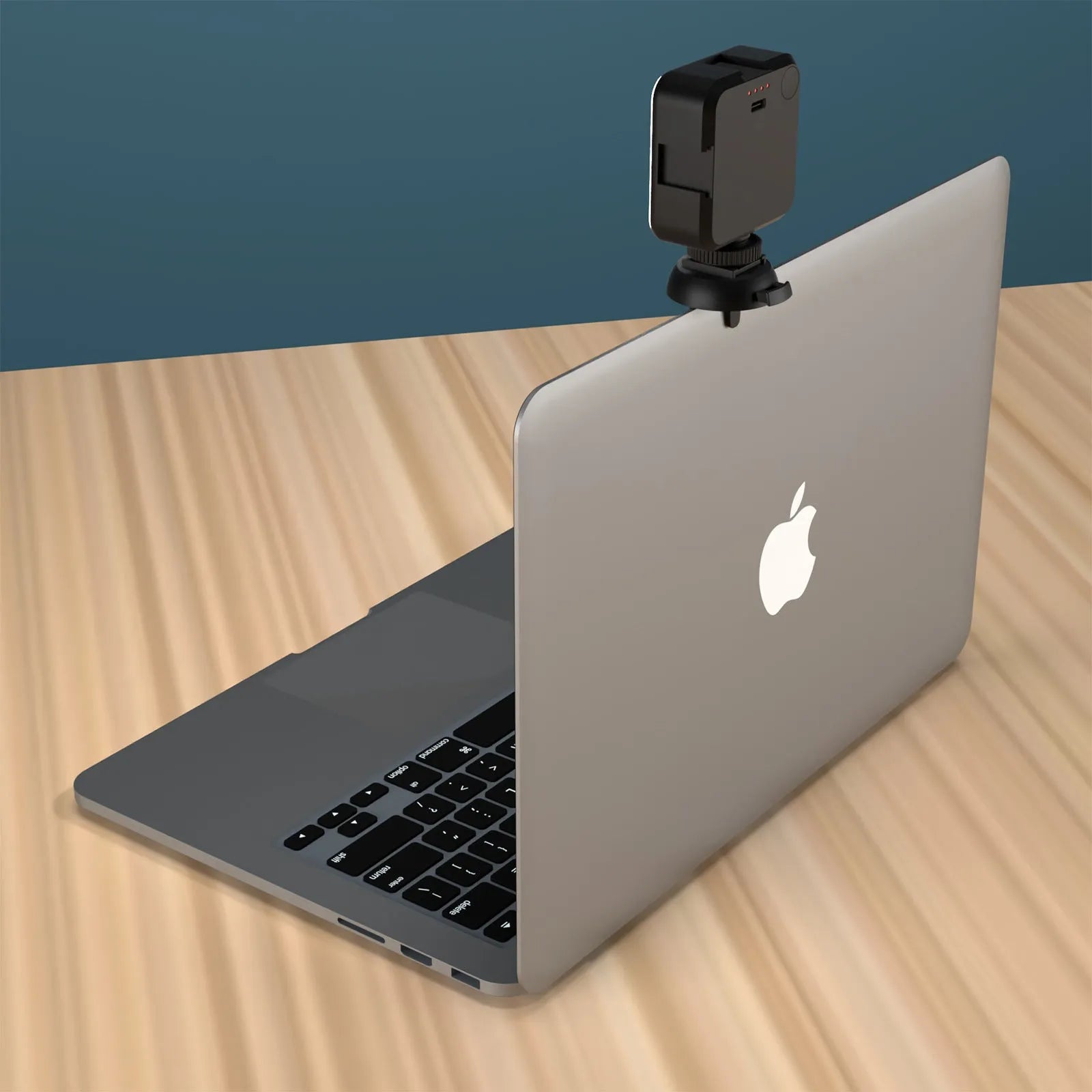 Silver 5600K LED video light cube clipped onto a laptop, with shelf and wire included