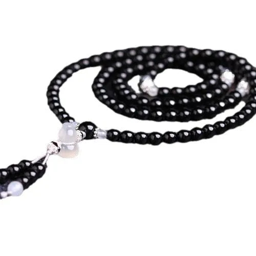 Natural black agate 108 bead bracelet with 8mm geometric beads on a wrist.