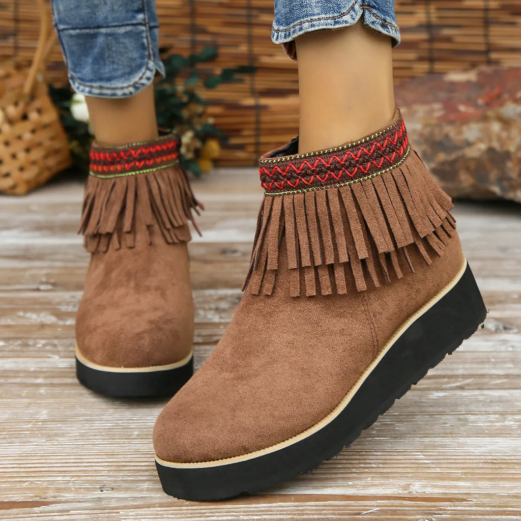 Women's black suede thick sole wedge ankle boots with side zip and tassel detail.