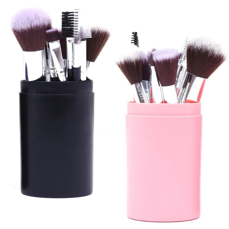 12 makeup brushes with pink handles and black bristles arranged in white storage bucket