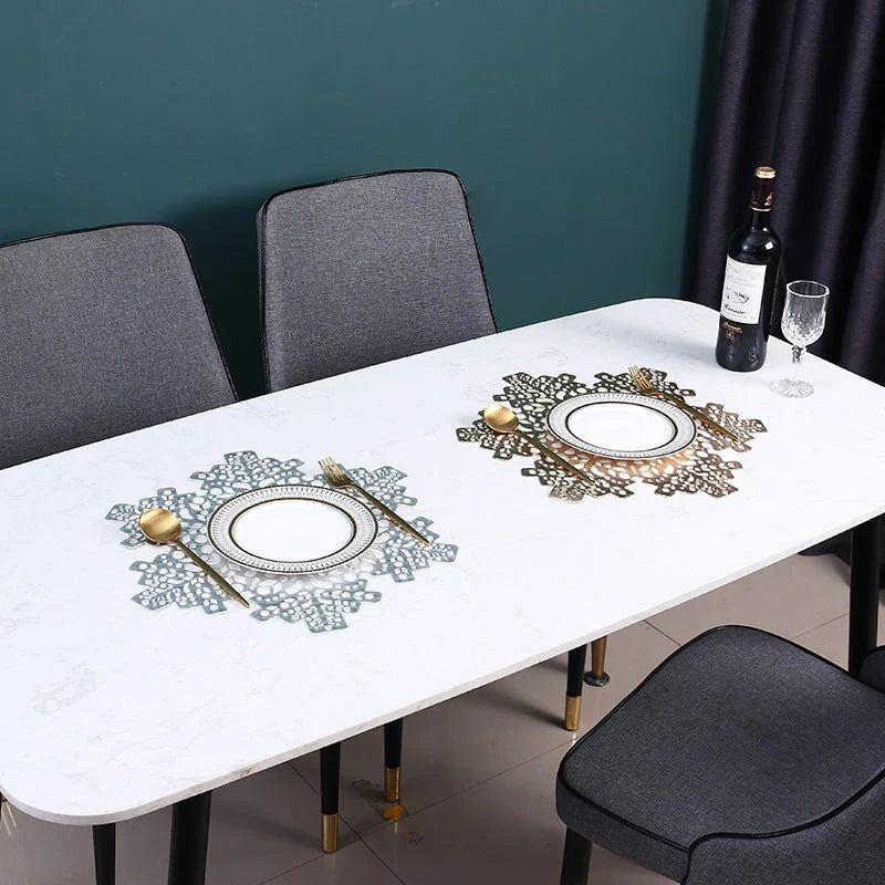 Stylish snowflake-patterned placemats in gold and silver, designed for heat resistance and spill protection on dining tables