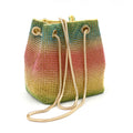 Sparkling rhinestone bucket bag with drawstring closure on a soft texture.