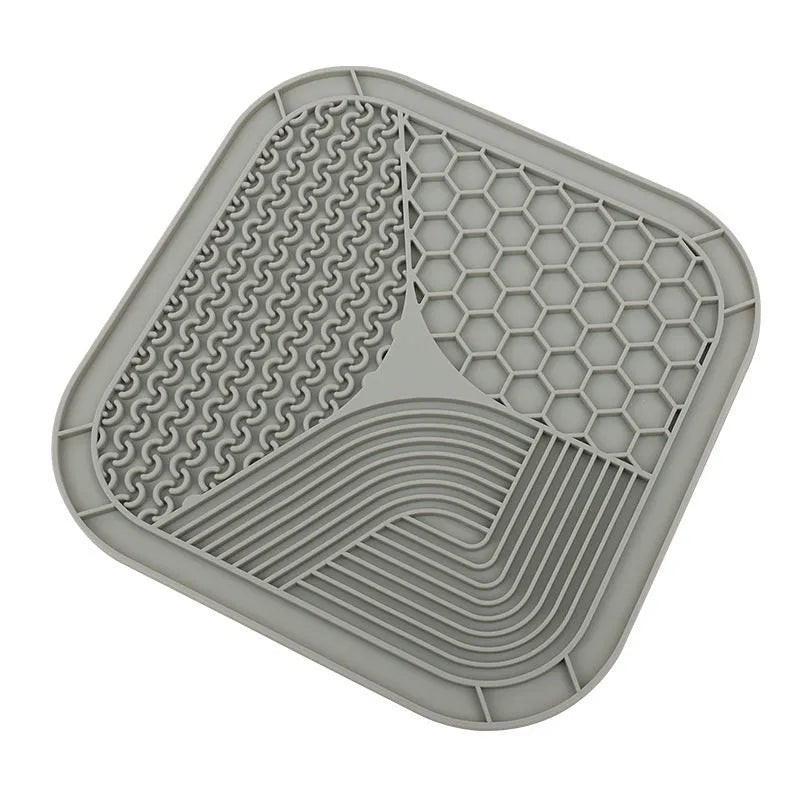 Gray silicone anti-choke slow feeding dog licking pad with textured surface on a flat surface
