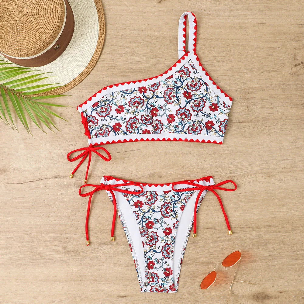 Women's blue floral one-shoulder bikini set with briefs-style bottom on mannequin