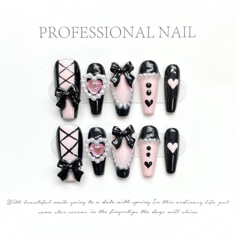 Black and pink heart pattern press-on nails with hand-painted bow decoration in cat's eye finish
