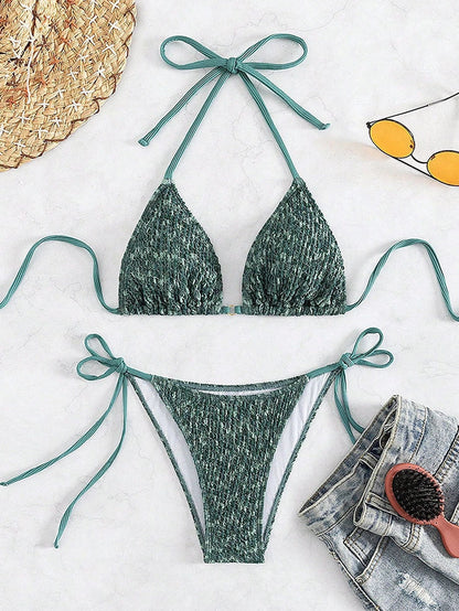 Green backless halter swimsuit with adjustable straps and matching shorts on mannequin