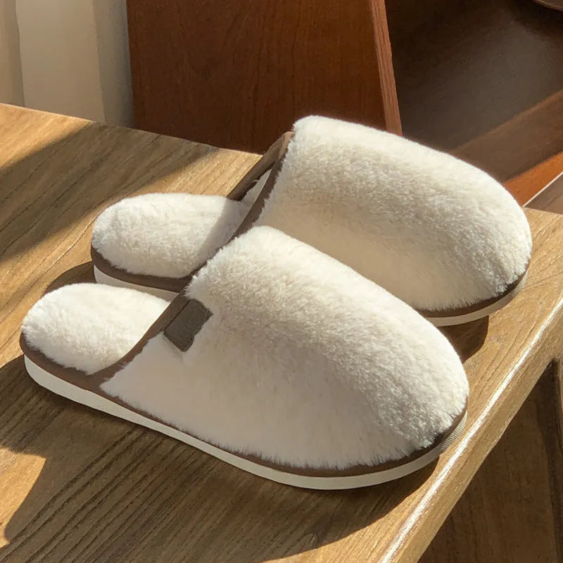 Blue plush slipper with non-slip PVC sole and car-stitching detail on a wooden floor.