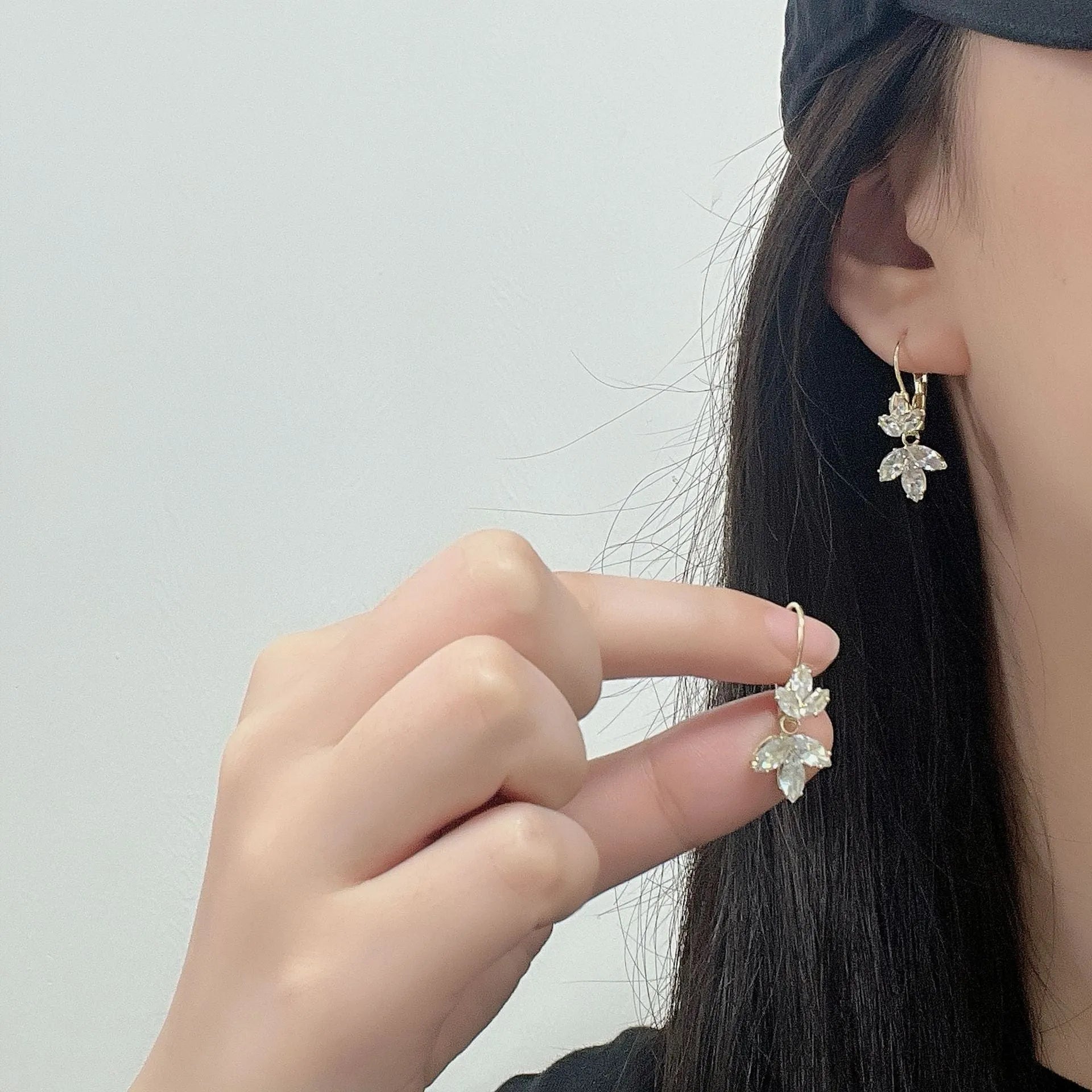 Women's platinum-colour leaf earrings with inlaid shiny zircon stones.