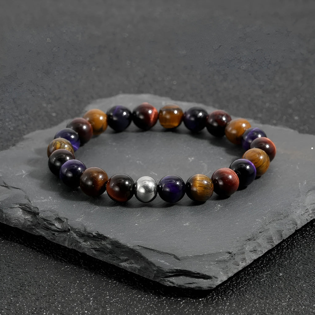 Handmade elastic tiger-eye stone bracelet in geometric shapes on a wrist.