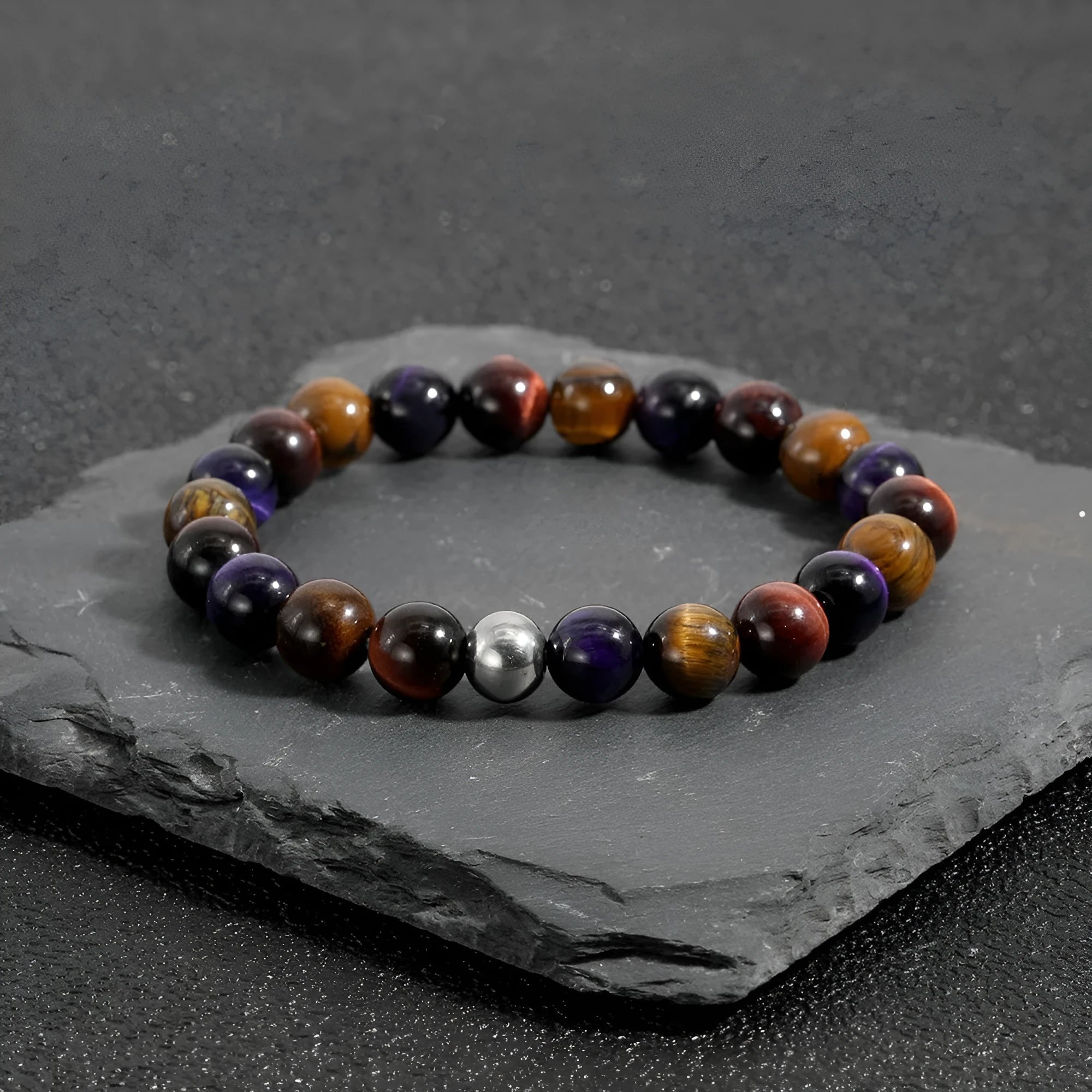 Handmade elastic tiger-eye stone bracelet in geometric shapes on a wrist.