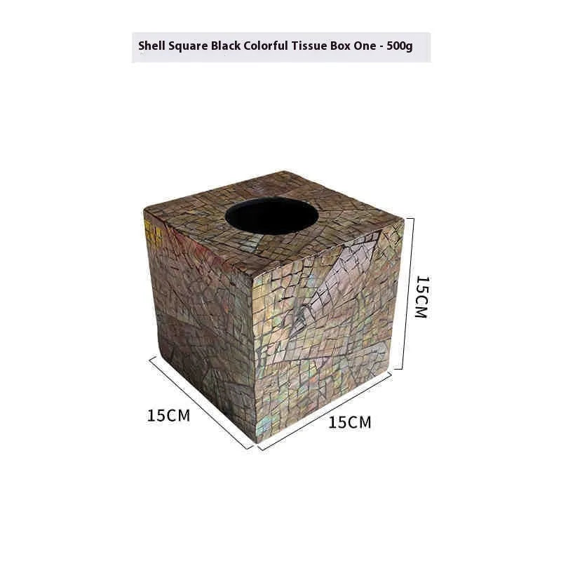A black rectangular shell tissue box holder with a removable lid on a wooden coffee table.