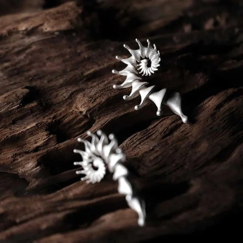 A pair of matte finish conch stud earrings with a three-dimensional, irregular alloy design.