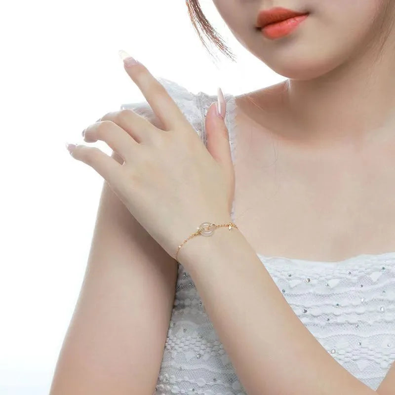 Gold-coloured women's silver bracelet with a peace buckle design and white chalcedony stone centrepiece.