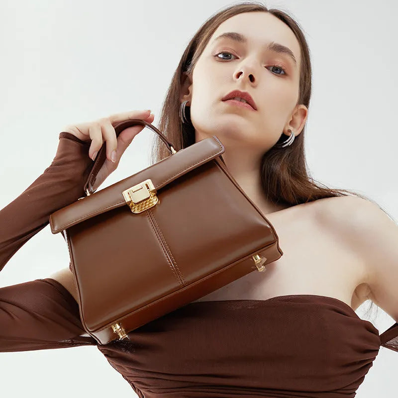 Black genuine leather women's shoulder bag with vachette clasp and long strap.