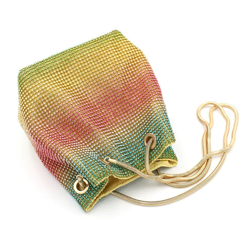 Sparkling rhinestone bucket bag with drawstring closure on a soft texture.