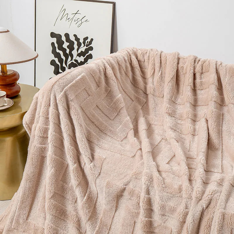 Thick coral fleece square blanket in a modern solid colour, draped over a sofa.