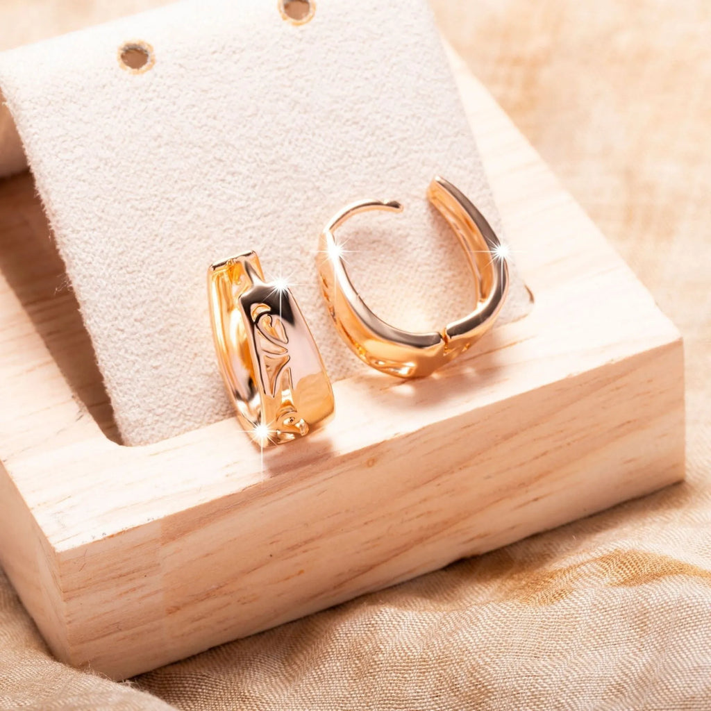 Rose gold copper hollow carved U-shaped women's earrings on a neutral background