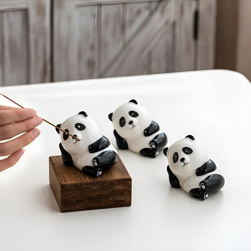 Ceramic panda incense holder in squinting style on a desk, 8.5cm high, with a lit incense stick