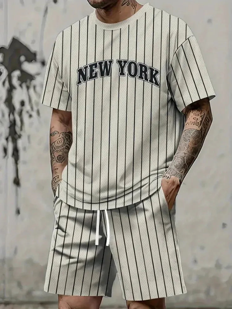 Man wearing a grey short sleeve top and matching shorts with a 3D printed white letter design.