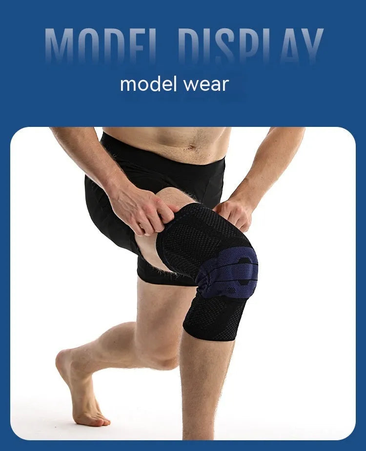 A pair of adult sports knee pads in a black and blue colourway, shown on a knee for scale.