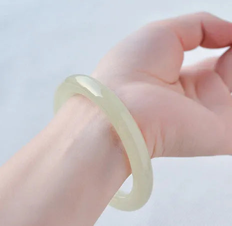Polished ice-like silk jade round bar bracelet showing its geometric shape and smooth surface