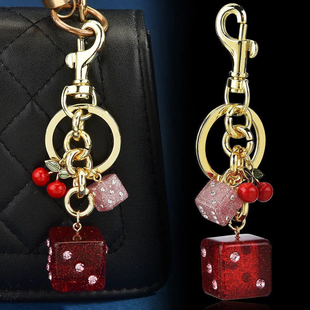 Square metal keychain pendant with a vintage two-tone cherry dice pattern.