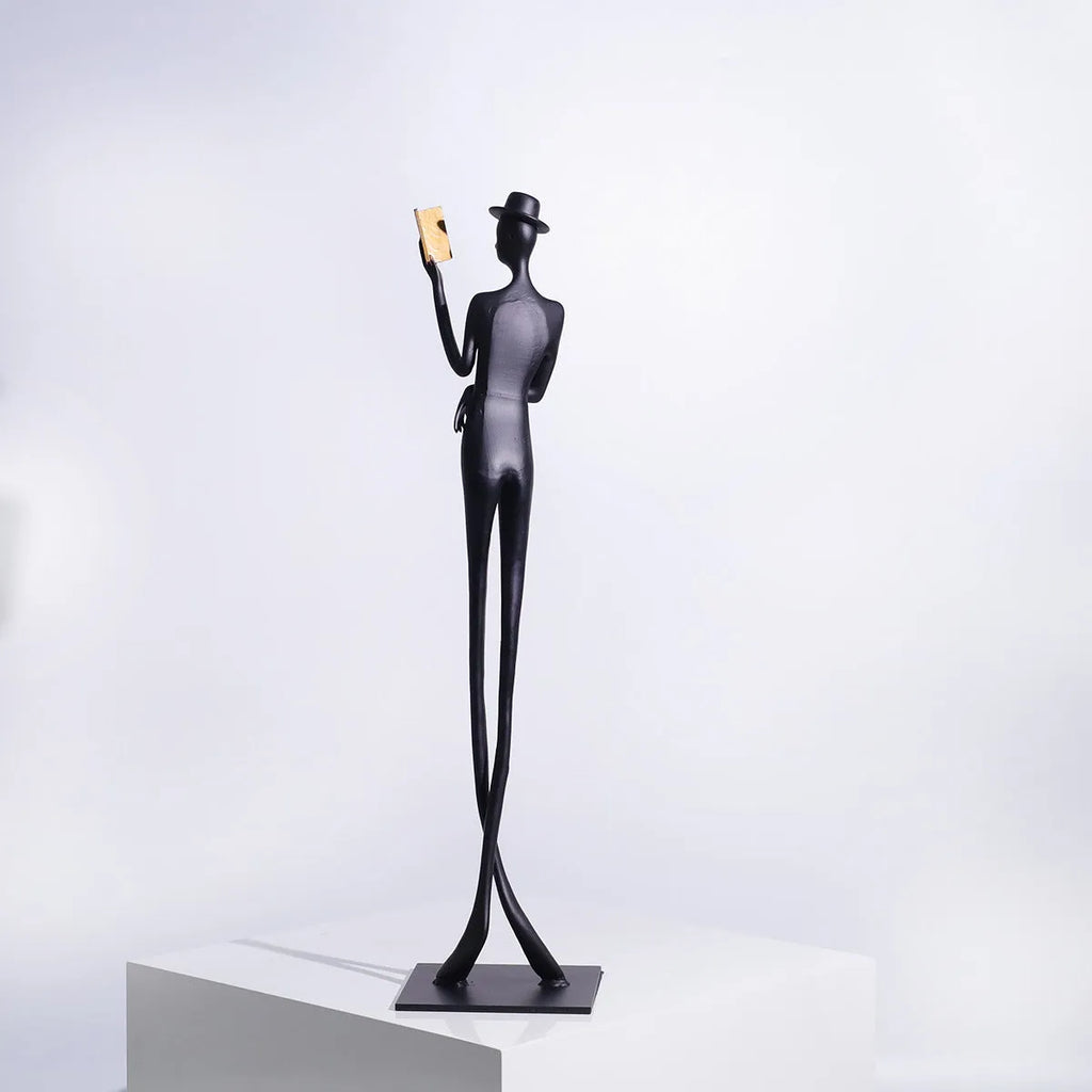 Black cast aluminium desktop sculpture of a woman reading, modern simplicity style, 51cm tall.
