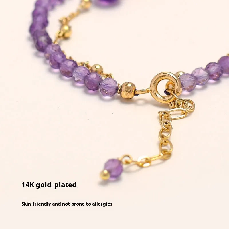 Close-up of a women's amethyst bracelet with diamond-cut crystal beads and Chinese style design.
