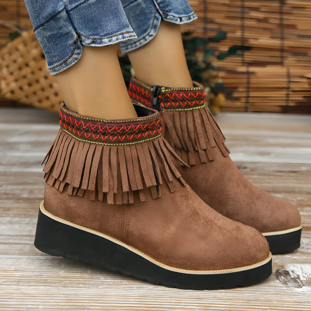 Women's black suede thick sole wedge ankle boots with side zip and tassel detail.