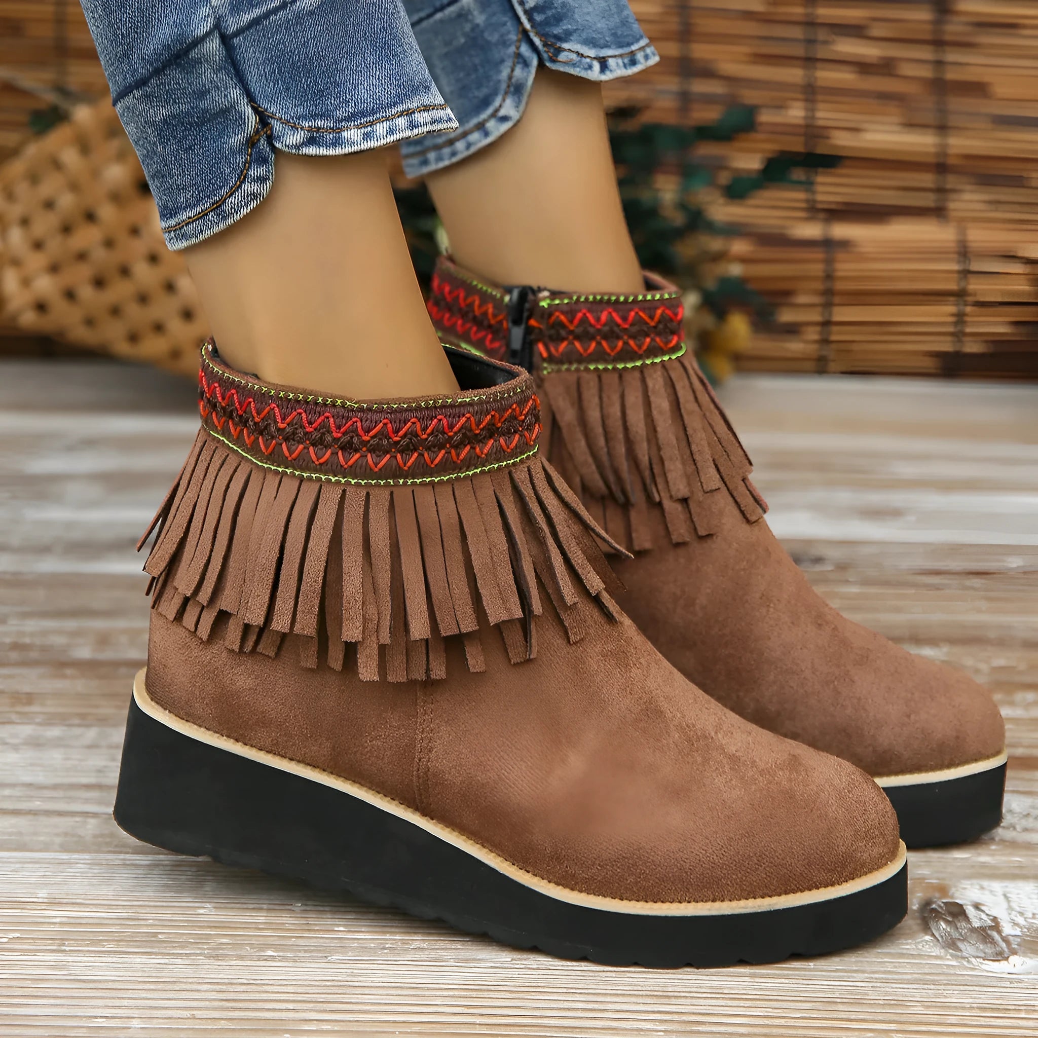 Women's black suede thick sole wedge ankle boots with side zip and tassel detail.