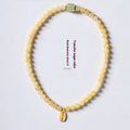 Topaz-coloured women's bracelet with six-word mantra barrel beads and sugar jade cubes in hand-woven design