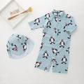 Boys' long sleeve penguin print swimsuit set with matching swim cap for sun protection.