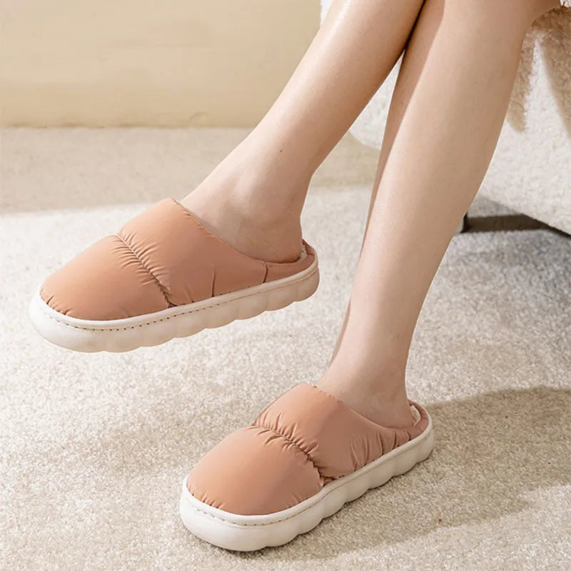 A pair of blue down cotton slippers with a thick sole, artificial leather upper, and plush lining for indoor winter wear.