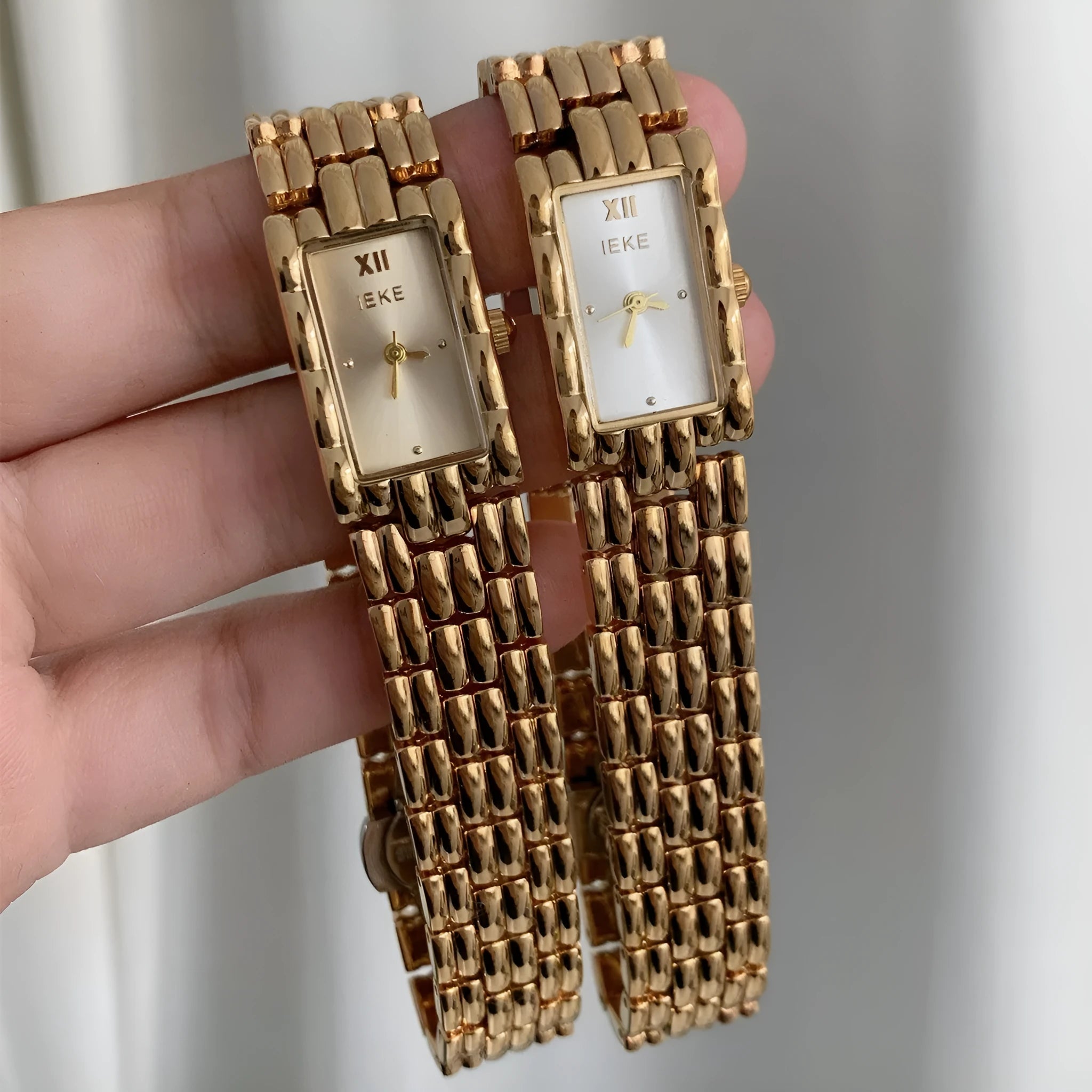 A bracelet-style ladies' watch with a stainless steel case, showing a choice of silver or gold finishes with white or grey dials.