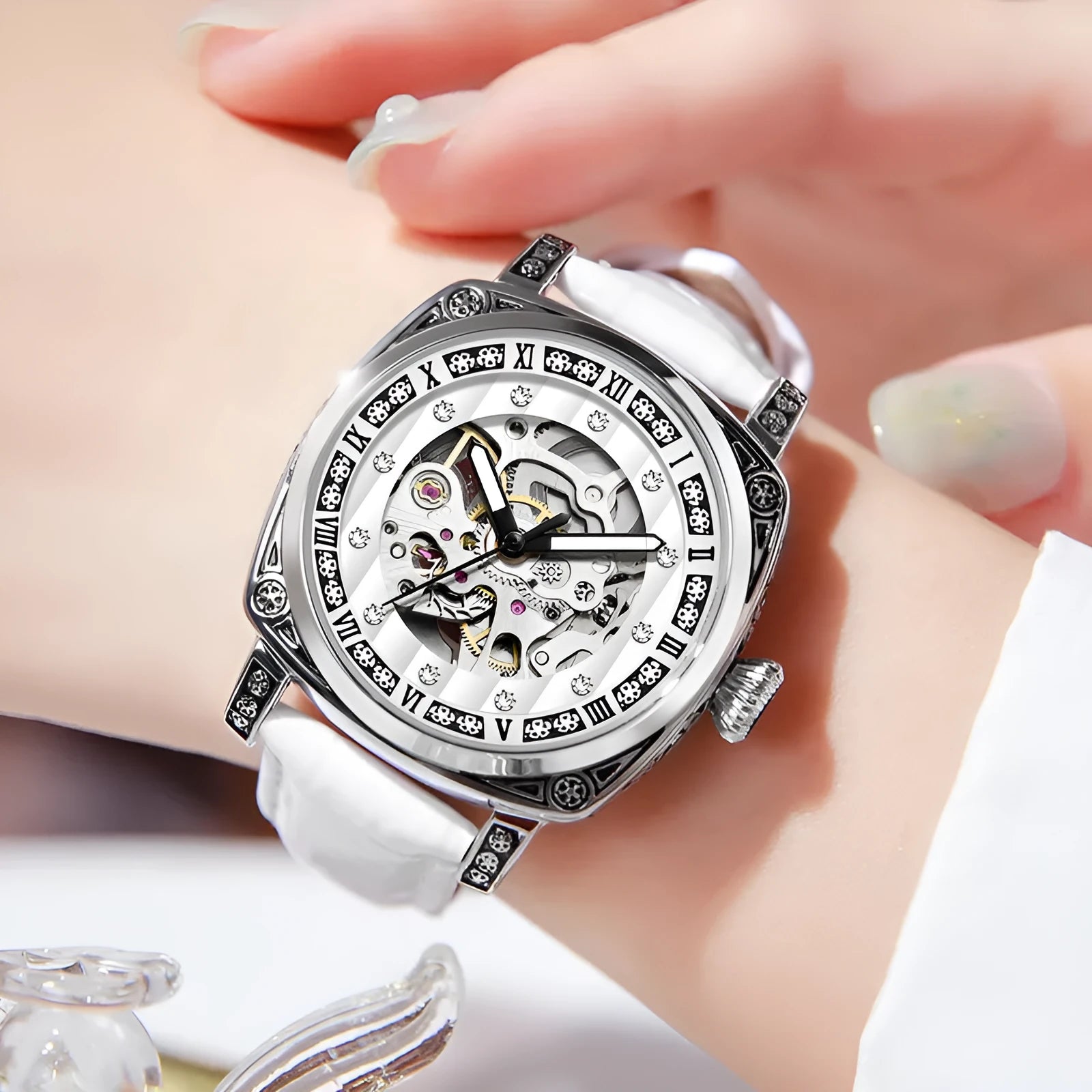 Mechanical watch with luminous hands and a brown leather strap, showing white dial.
