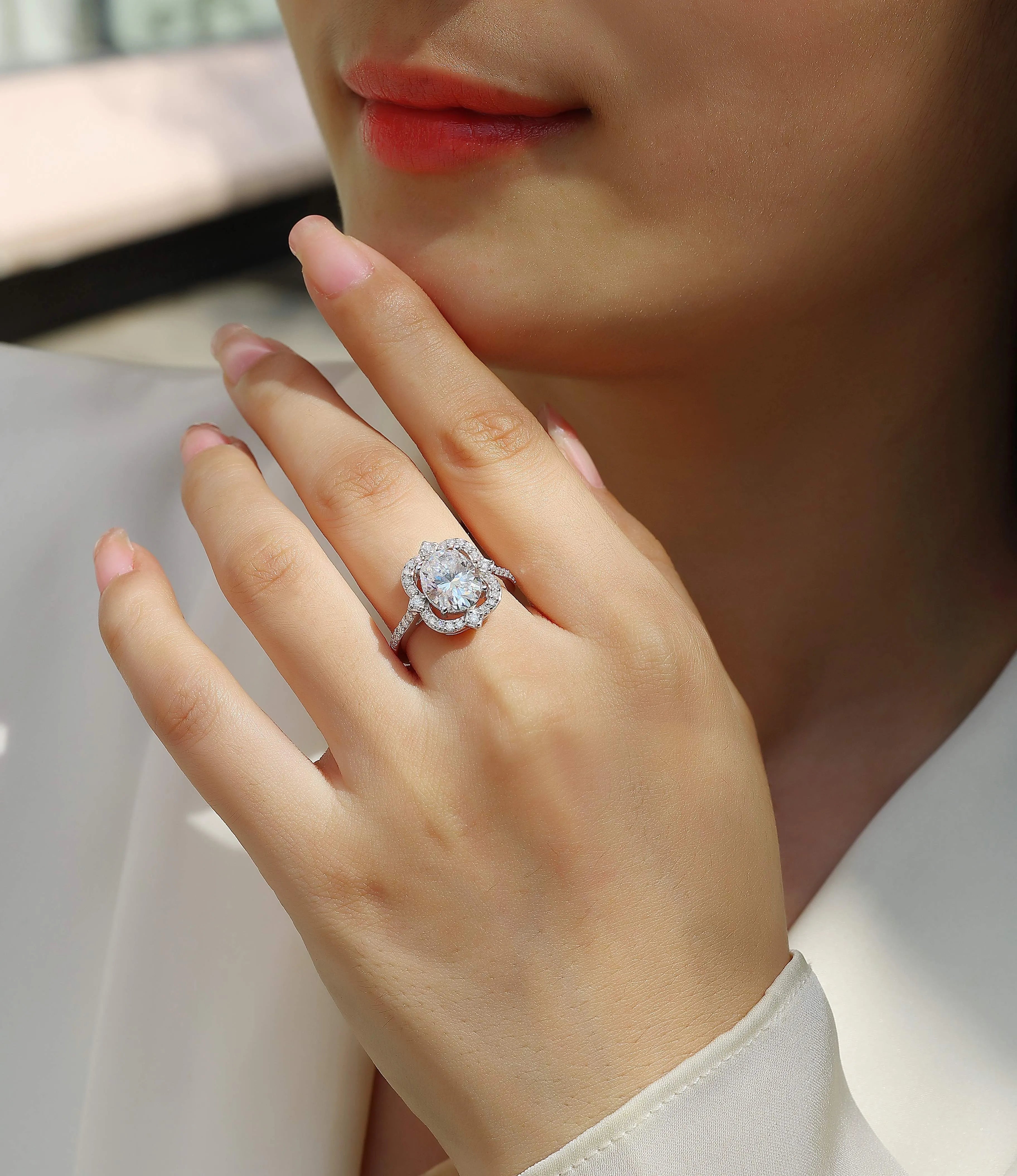 Egg-shaped moissanite ring set with S925 silver and platinum plating on a white surface