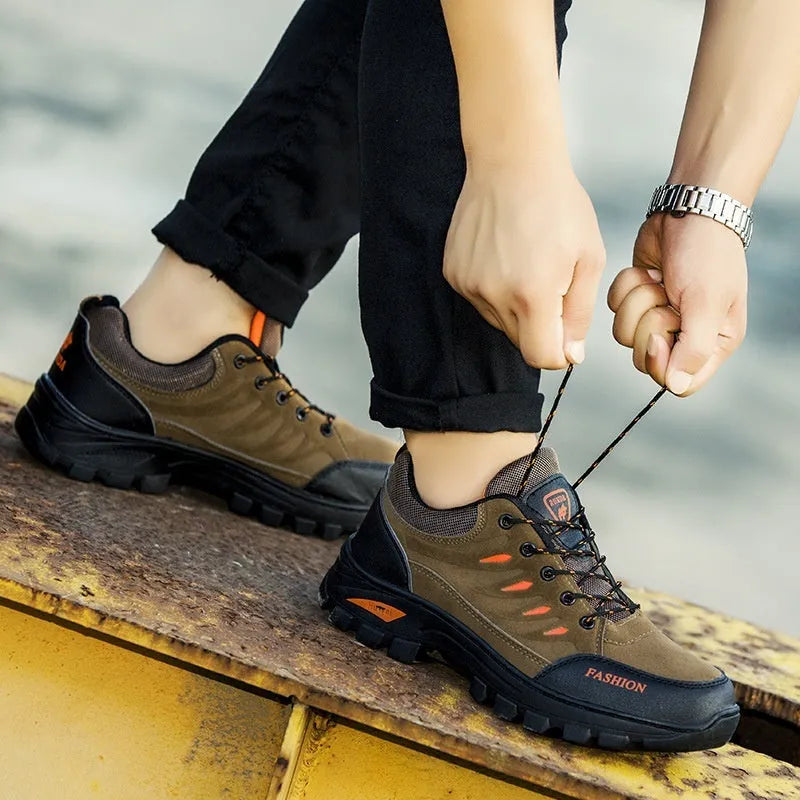 Men's brown suede hiking shoes with rubber sole and lace-up closure, showing round toe and mid-top design