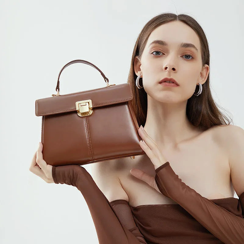 Black genuine leather women's shoulder bag with vachette clasp and long strap.